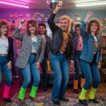 Mladí ľudia v 80. rokoch tancujú v izbovej párty s neonovým oblečením a retro dekoráciami